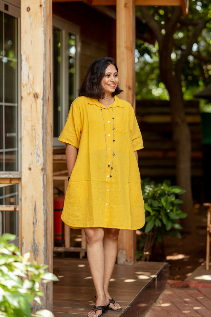 A woman in a knee length yellow midi dress 